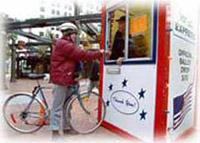 A woman on a bicycle hands her ballot in at an official drop site in Portland, Oregon in the 2000 presidential election.
